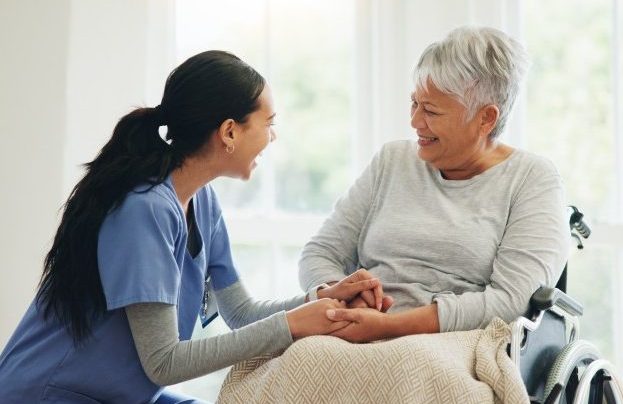 Happy nurse with elderly lady who is in wheelchair