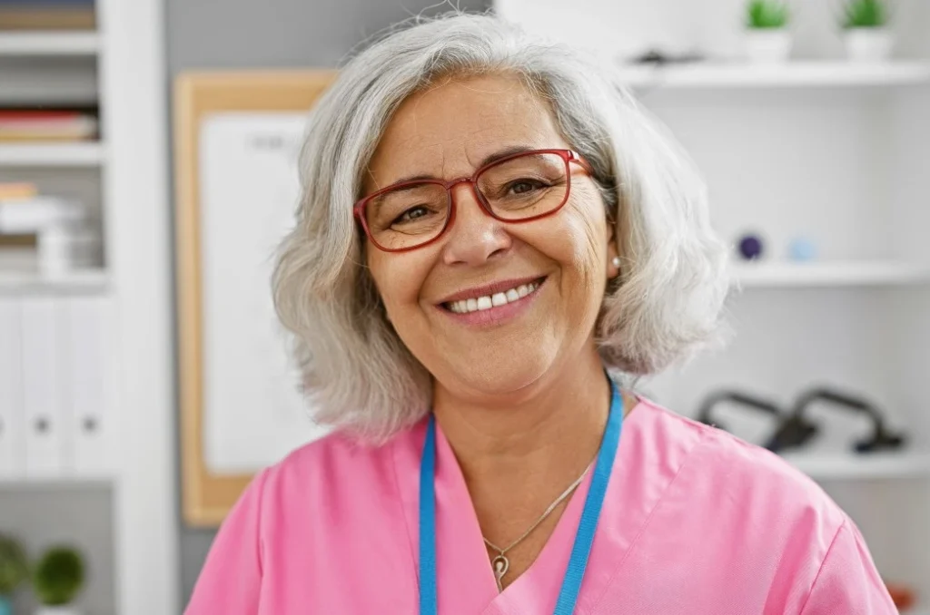 Happy middle-aged caregiver smiling at camera